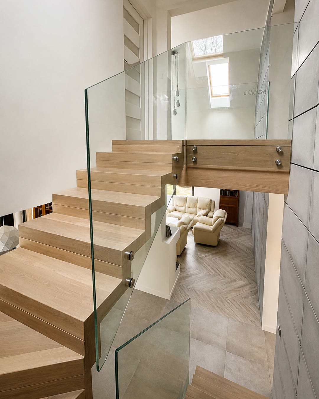 Dywanowe schody dębowe ze szklaną balustradą i antresolą
