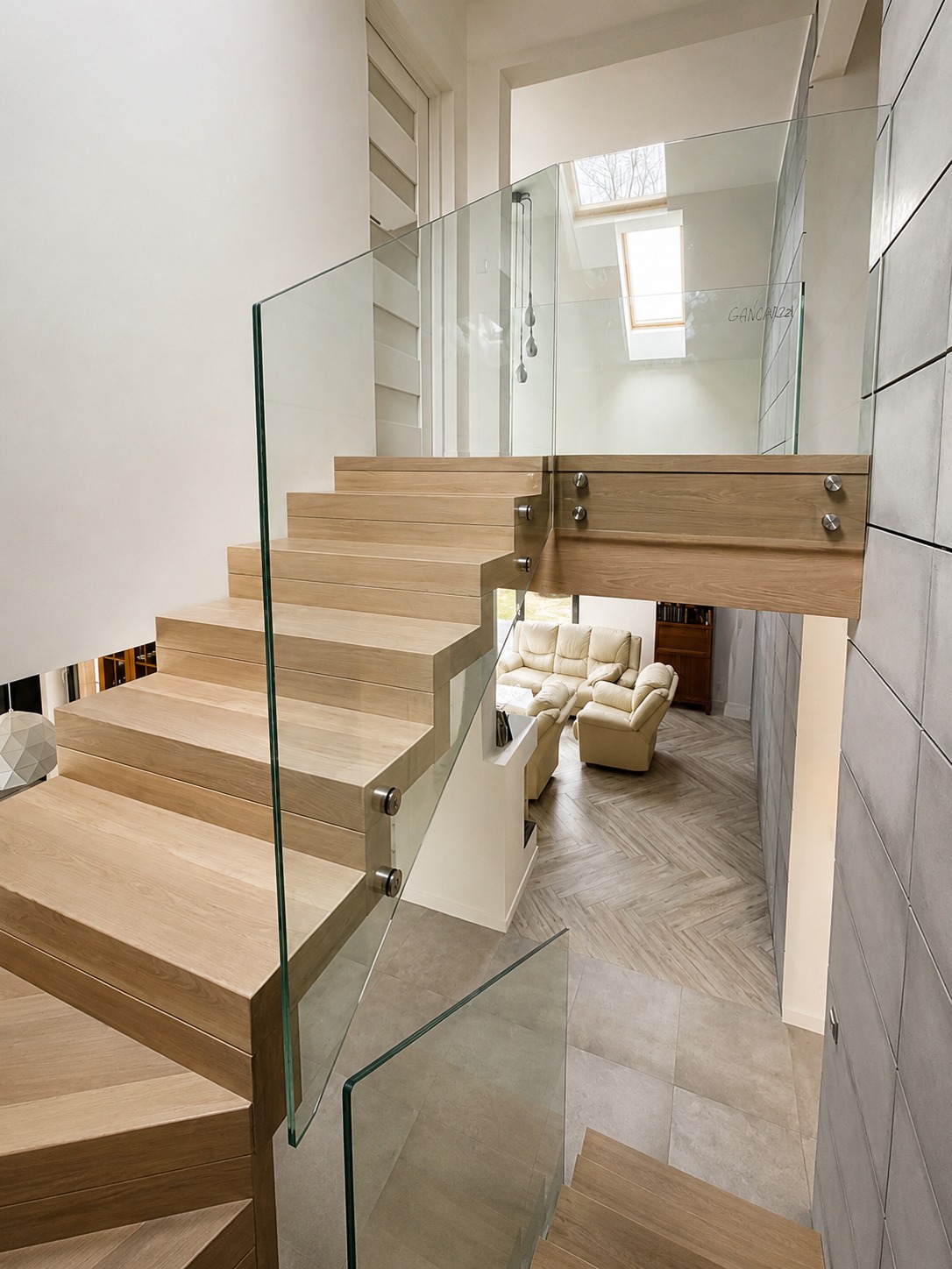 Dębowe schody samonośne ze szklaną balustradą